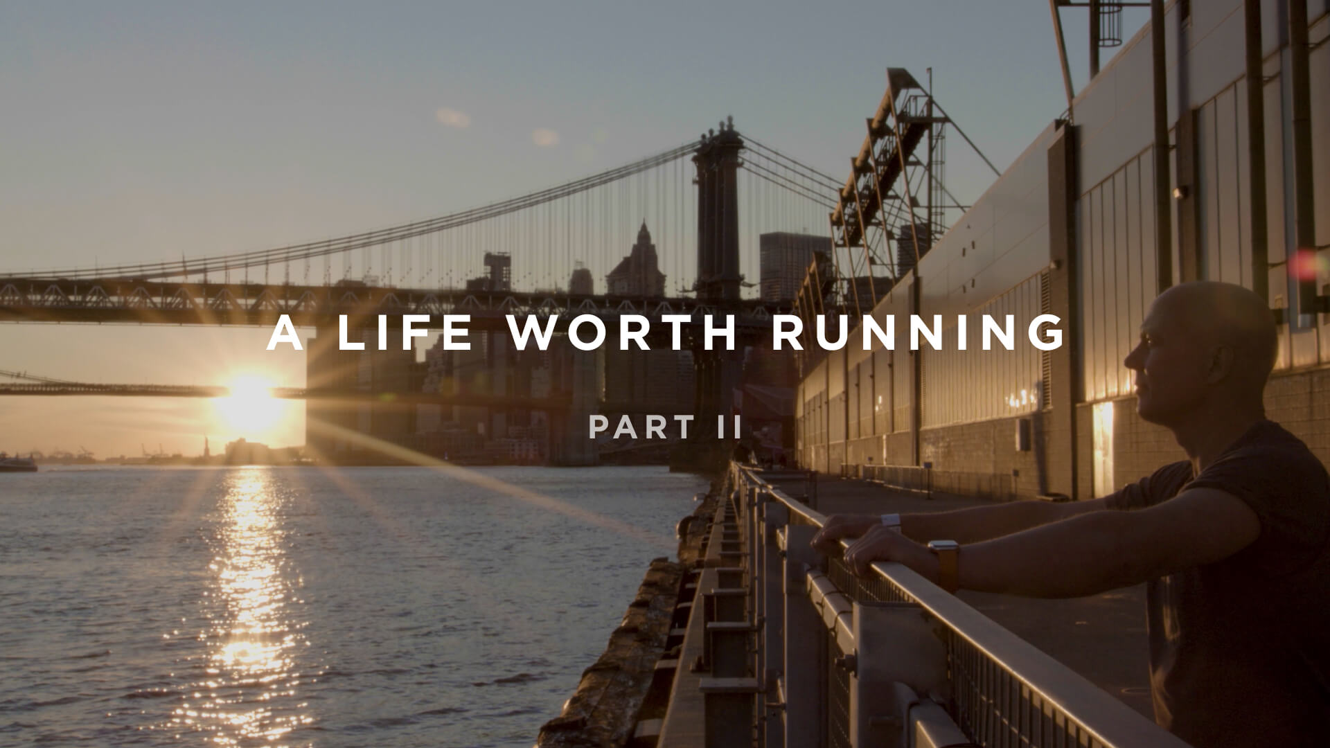 Person standing by a railing, contemplating life as the sun sets over the water, with a bridge in the background. Text reads: "A Life Worth Running Part II.