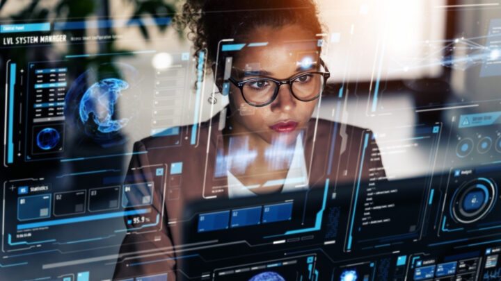 A person wearing glasses is intently focused on digital futuristic screens displaying data and graphics, exploring the integration of AI in market research.
