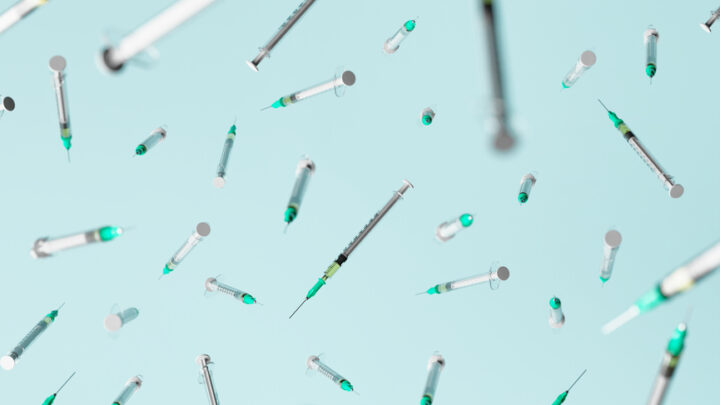 Floating syringes with needles and green caps, reminiscent of vaccine doses, are scattered against a light blue background.