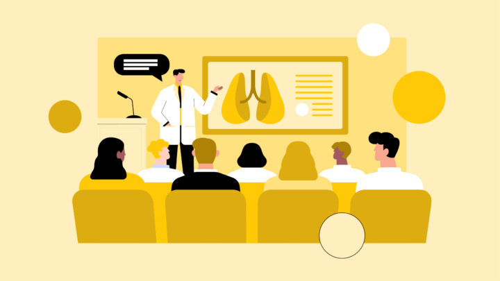 A person in a lab coat presents information about lungs to an audience seated in a lecture hall, sharing insights on what medical school doesn’t teach you about real-world respiratory care.