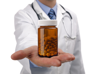A doctor in a white coat extends a hand, offering a brown pill bottle often filled with unproven supplements, set against a plain background.