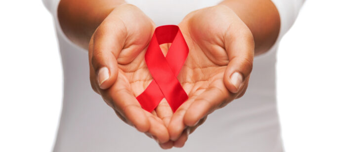 Hands gently cradle a red ribbon, symbolizing support for HIV/AIDS awareness and emphasizing the importance of prevention in women's health.