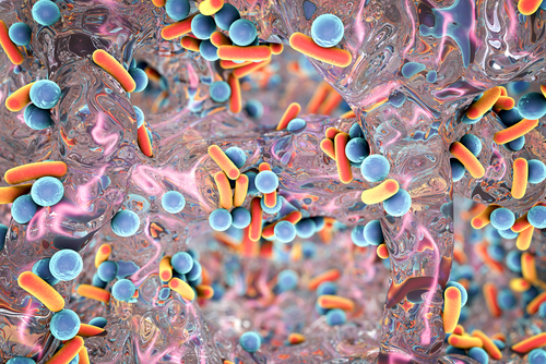 Abstract image of blue and orange bacteria intertwined with a colorful, shiny substance, possibly representing a biofilm or microbial environment indicative of an STD.