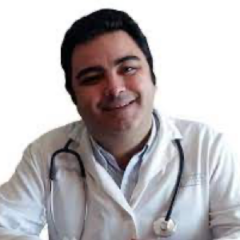 Dr. Jesús Alcaraz Rubio, MD, in a white coat with a stethoscope, smiles warmly at the camera.